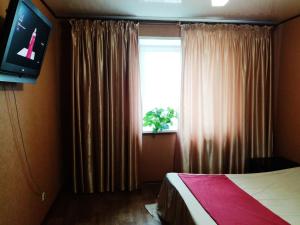 ヨシュカル・オラにあるКвартира на Пролетарской 44のベッドルーム1室(ベッド1台付)、窓(カーテン付)