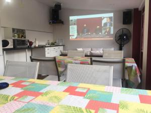 un comedor con mesas, sillas y una pantalla en Casa de sol, piscina y jacuzzi con 4 hab en Comunidad de Madrid, en Algete