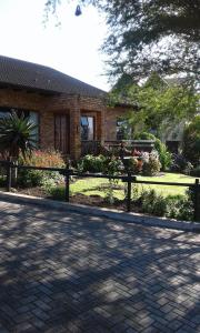 a brick house with a fence in front of it at Marlin Cottage in Chintsa