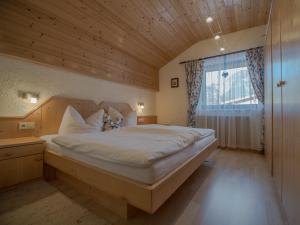 1 dormitorio con 1 cama grande y techo de madera en Haus Christine, en Leutasch