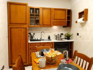 a kitchen with wooden cabinets and a table with a bowl on it at FraBa Apartment in Naples