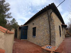 een stenen gebouw met een blauwe deur erop bij xalet l’avella 2 in Catí
