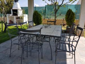 une table et des chaises assises sur une terrasse dans l'établissement Tres Hermanos CON PISCINA PRIVADA, à Pelabravo