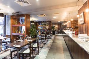 um restaurante com mesas e cadeiras e um bar em Holiday Inn Newcastle-Jesmond, an IHG Hotel em Newcastle upon Tyne
