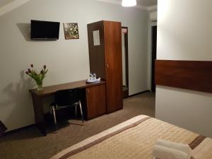 a hotel room with a bed and a desk with a computer at Pokoje Bakos Radocza in Radocza