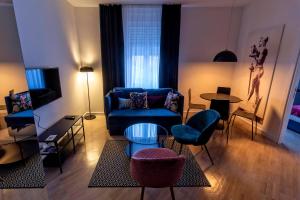 un soggiorno con divano blu e tavolo di Momo 123 Apartments a Belgrado