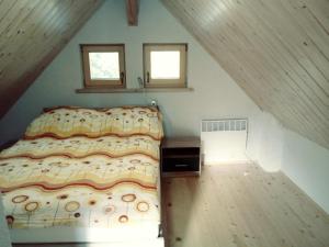 ein Schlafzimmer mit einem Bett im Dachgeschoss mit zwei Fenstern in der Unterkunft apartma HIŠKA KOROŠEC in Bohinj