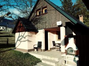 una pequeña casa con sillas y una mesa. en apartma HIŠKA KOROŠEC en Bohinj