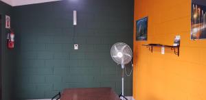um quarto com uma ventoinha e uma parede verde em Residencia Jose Maria em Santa Rosa de Calamuchita