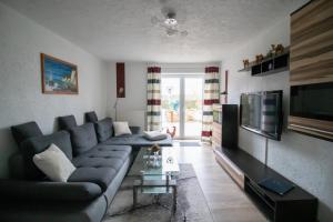 a living room with a couch and a television at Ferienwohnung Feldstein in Hohenkirchen