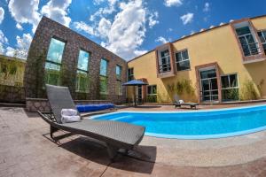 a swimming pool with a chair and a house at Hotel Camino de Piedra in Guanajuato