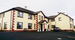 una casa con un coche aparcado delante en Station House Bed & Breakfast, en Ennistymon