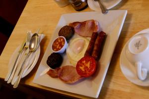 a plate of breakfast food with eggs sausage and tomatoes at Station House Bed & Breakfast in Ennistymon