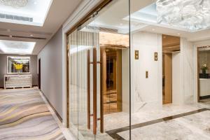 um corredor com paredes de vidro e um átrio com uma escada em Holiday Inn Macau, an IHG Hotel em Macau