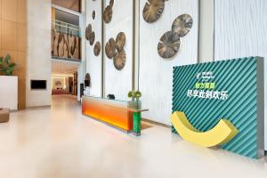 a lobby with a yellow chair and clocks on the wall at Holiday Inn Shanghai Pudong, an IHG Hotel in Shanghai
