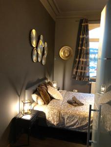 1 dormitorio con cama con almohadas y ventana en LA SUITE 159 en Namur