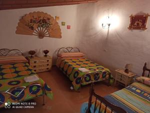 sypialnia z 2 łóżkami i znakiem na ścianie w obiekcie casa cueva la fuente 2 w mieście Fontanar