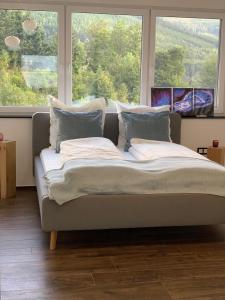 a bed sitting in front of a window at Luxus-Ferienwohnung Saalhausen in Saalhausen