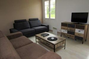 a living room with a couch and a flat screen tv at Maison individuelle Côte Basque ( Ciboure ) in Ciboure