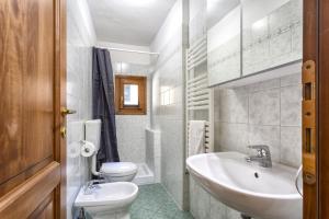 a white bathroom with a sink and a toilet at Fiume & Zannoni Apartments by 360Rentals in Florence