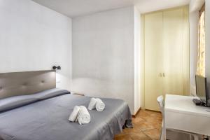 1 dormitorio con 1 cama con 2 toallas en Fiume & Zannoni Apartments by 360Rentals, en Florencia