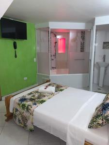 a bedroom with two beds and a bathroom with a shower at Hotel Las Guacamayas Guatapé in Guatapé