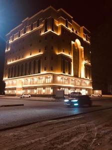 a building at night with cars driving past it at Makarem Residence - Hotel Apartments in Al Khobar