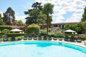 einen Pool mit Stühlen und Sonnenschirmen in der Unterkunft Villa Royal in Florenz