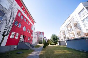 a red building is next to two white buildings at Barko Residence 1 in Braşov