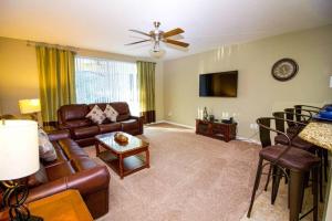 a living room with a couch and a tv at Tuscany at Westside Luxury 5 Bed, 4 Bath Villa near Disney in Kissimmee