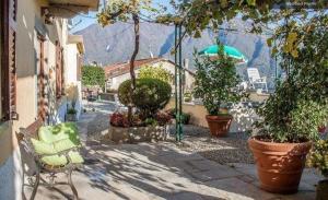 a patio with plants and a chair and an umbrella at Bellavita Fossati in Carate Urio