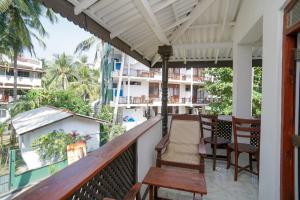 a balcony of a hotel with chairs and tables at Sea view Beach Resort in Unawatuna