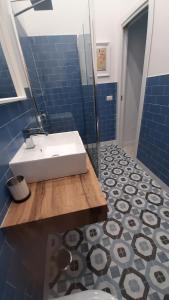 a bathroom with a white sink and blue tiles at Palazzetto di Neubourg in Naples