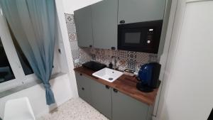 a small kitchen with a wooden counter and a microwave at Palazzetto di Neubourg in Naples