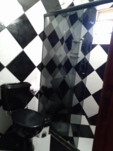 a black and white tiled bathroom with a toilet at Casa temporada ilheus in Ilhéus