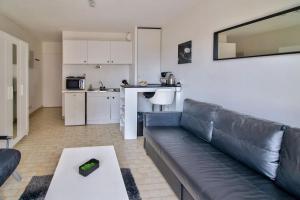 uma sala de estar com um sofá e uma cozinha em STUDIO DESIGN NEAR GENEVA em Étrembières