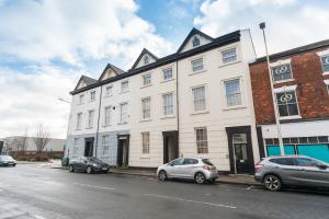 a white building with cars parked in front of it at Jesouth Mezzanine Suite - Comfy Homey Pleasant City Centre Wifi in Hull