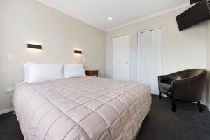 
a hotel room with a bed and a television at Tower Lodge Motel in Invercargill
