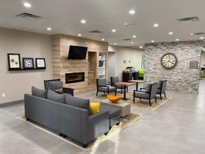 a lobby with a couch and chairs and a fireplace at Country Inn & Suites by Radisson, Oklahoma City - Bricktown, OK in Oklahoma City