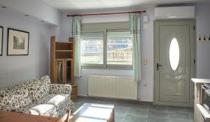 ein Wohnzimmer mit einer Couch und einem Fenster in der Unterkunft Varvara Lake Dramatown Studio in Drama