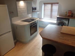a kitchen with a sink and a stove top oven at Modern Town Apartment with Terrace in West Kirby
