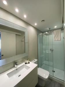 a bathroom with a sink and a shower and a toilet at Golden Beach Guest House & Rooftop Bar in Faro +89 photos