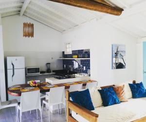 una cucina e una sala da pranzo con un tavolo e un divano di Vila dos Lençóis a Santa Cruz Cabrália