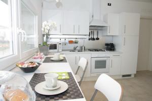 a kitchen with white cabinets and a table and chairs at B&B Marostica in Marostica +4 photos