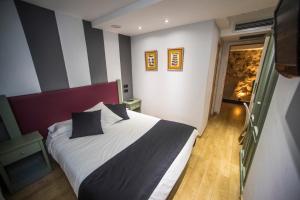 een slaapkamer met een groot bed met zwarte en witte strepen bij Boutique Hotel Castilla in Soria