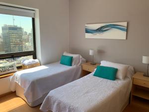 ブエノスアイレスにあるBuenos Aires View - Apart 2 Amb sobre Av Corrientesのベッド2台と窓が備わるホテルルームです。