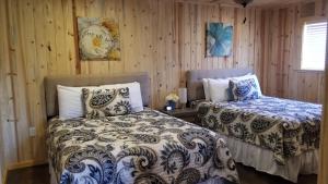 - 2 lits dans une chambre dotée de murs en bois dans l'établissement Bluff Gardens, à Bluff