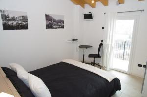 a bedroom with a black and white bed and a window at B&B Marostica in Marostica