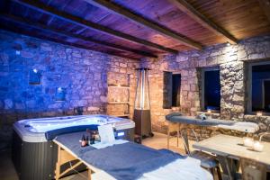Amallini Suites Mykonos في سوبر بارادايس بيتش: غرفة مع حوض استحمام وجدار حجري