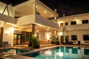 a house with a swimming pool in front of a building at Hotel Tres Soles in Ciudad Madero